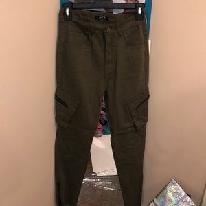 Olive green pants with zippers on the side.
